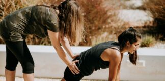woman in black tank top and black shorts kneeling on mat