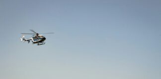 a helicopter flying over a mountain range on a clear day
