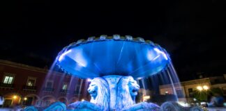 lion fountain with blue light in middle of fountain