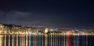 the city lights shine brightly on the water