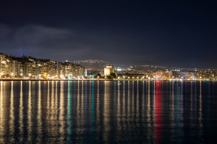 the city lights shine brightly on the water