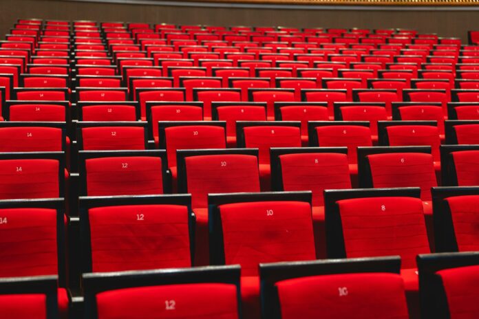 Rows of red chairs in a large auditorium