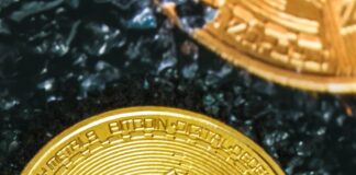 two gold bitcoins sitting on top of each other