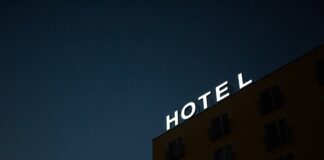low-angle photo of Hotel lighted signage on top of brown building during nighttime