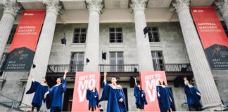 graduates in front of building