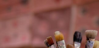 brown and red paint brush in clear glass container