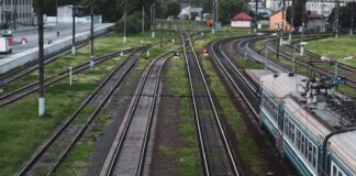 green train on rail tracks during daytime