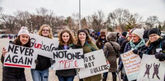 a group of people holding up signs in a parking lot