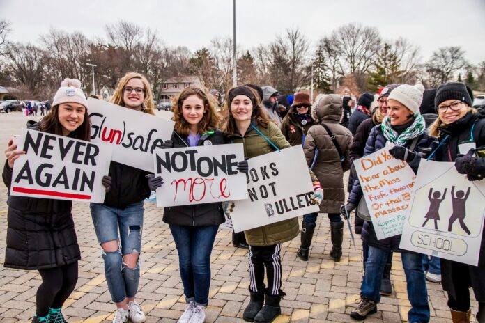 a group of people holding up signs in a parking lot