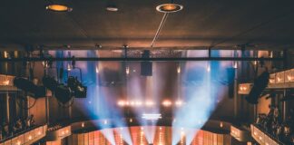 people standing on stage with lights turned on during nighttime