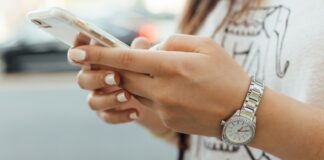 woman holding iPhone during daytime