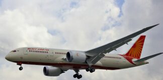 white and red airplane under white clouds