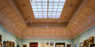 A room filled with lots of paintings and a skylight