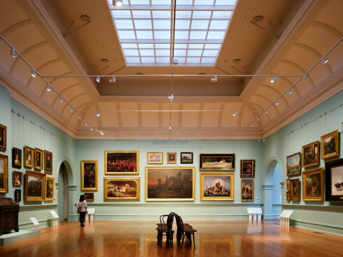 A room filled with lots of paintings and a skylight