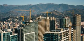 a city with tall buildings and cranes in the background