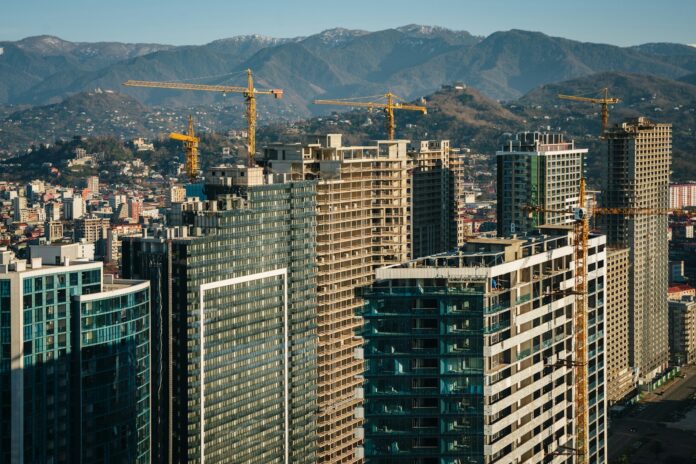 a city with tall buildings and cranes in the background