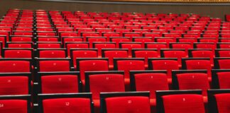 Rows of red chairs in a large auditorium