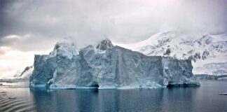 white iceberg near white mountains