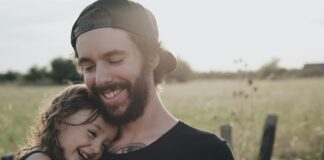 man carrying daughter in black sleeveless top