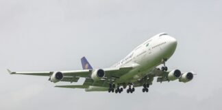 A large jetliner flying through a cloudy sky