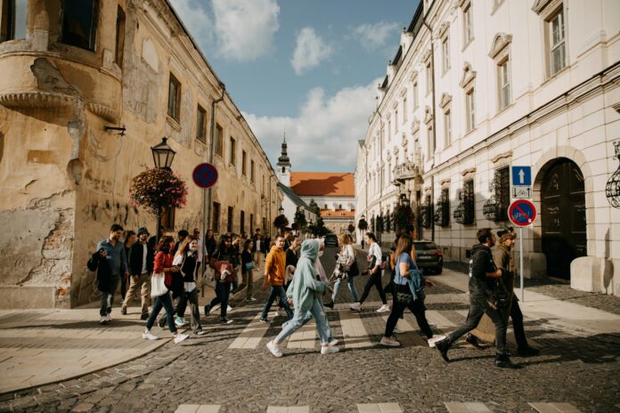 a group of people walking across a street