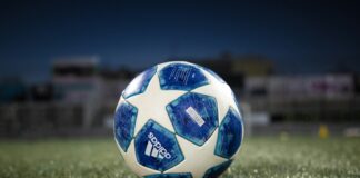 white and blue soccer ball on green grass field