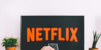 person holding remote pointing at TV