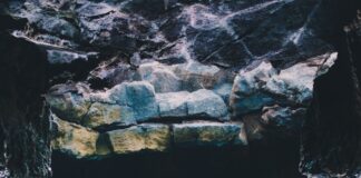 person submerged in water on cave