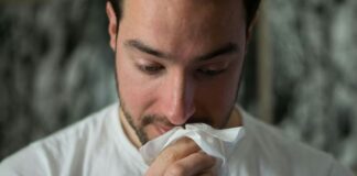man wiping mouse with tissue paper