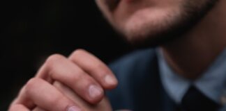 shallow focus photo of person wearing round black chronograph watch