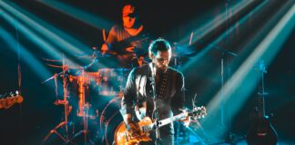 man in black leather jacket playing guitar