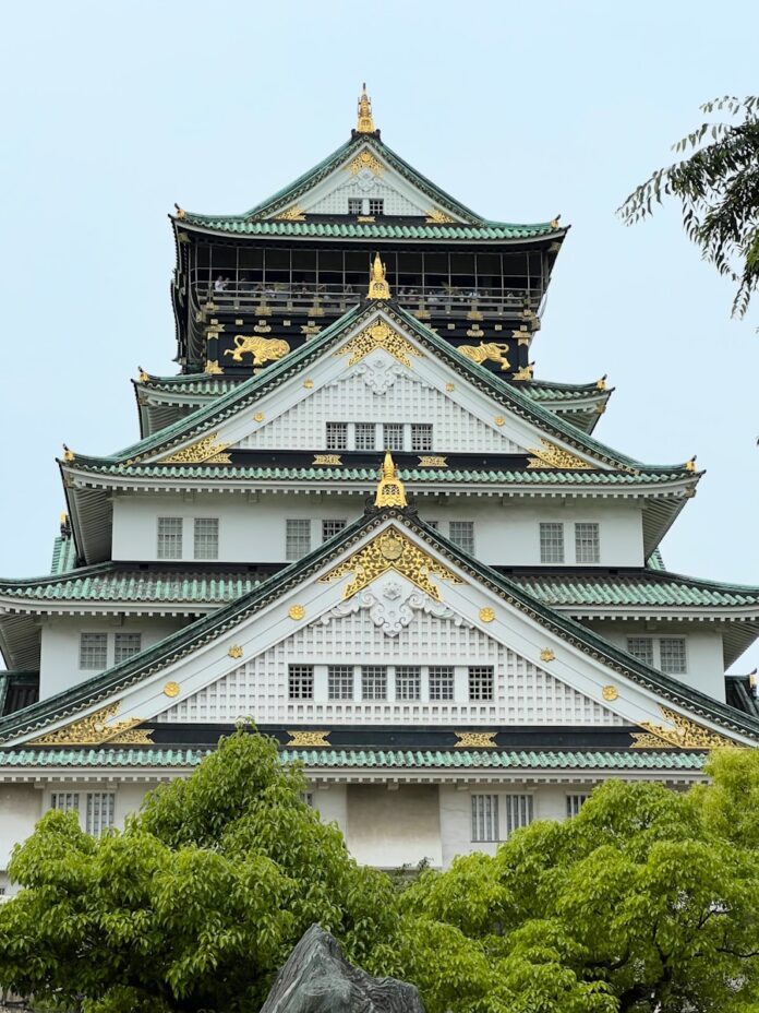 a large white and gold building surrounded by trees