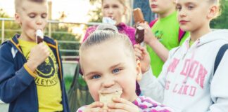 boy in white and pink striped long sleeve shirt holding ice cream