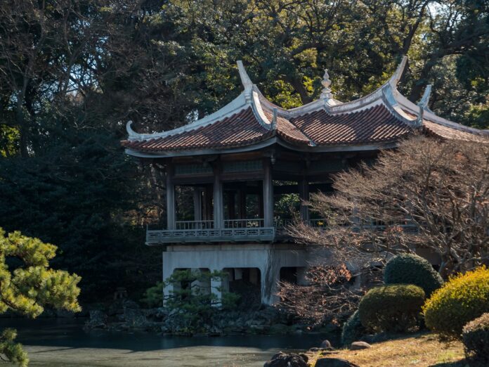 a building in the middle of a pond surrounded by trees