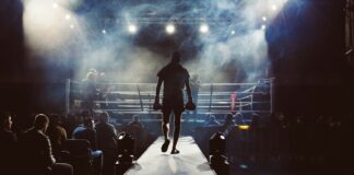 man standing and walking going on boxing ring surrounded with people