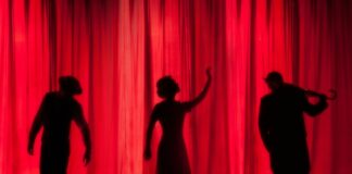 silhouette of three performers on stage