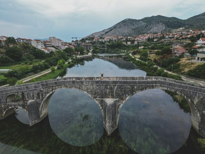 a person standing on a bridge over a river