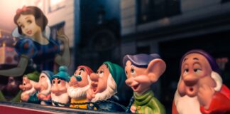 a row of snow white figurines sitting on top of a shelf