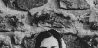 woman in white shirt standing near wall