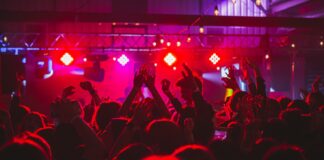 people standing on stage with lights turned on during nighttime