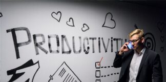 man holding smartphone looking at productivity wall decor