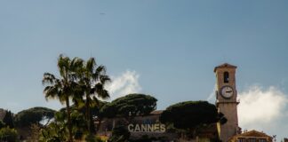 a clock tower on top of a building next to palm trees