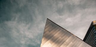 low angle photography of brown concrete building under gray clouds during daytime