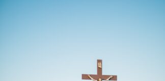 Crucifix statue on green grass