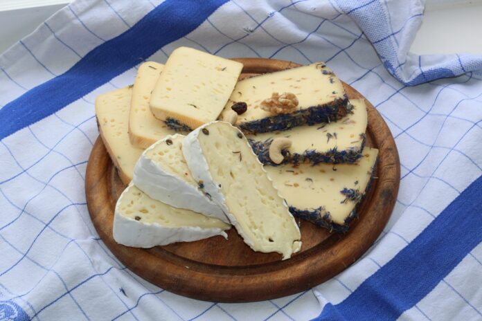 Cheese slices arranged on a wooden platter.