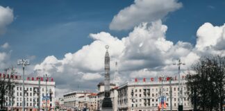 white and brown concrete building under white clouds and blue sky during daytime