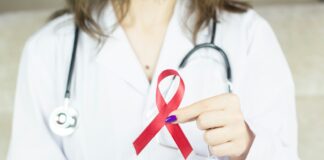 a woman in a white shirt holding a red ribbon