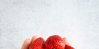 strawberries on persons hand