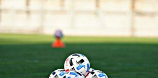 white blue and red soccer ball on green grass field during daytime