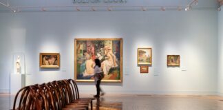 A room filled with wooden chairs and paintings